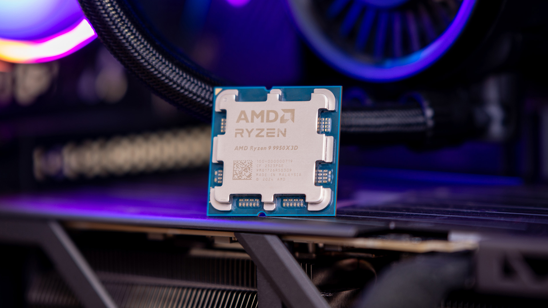 AMD Ryzen 9 9950X3D processor resting inside a PC build with purple RGB lighting.