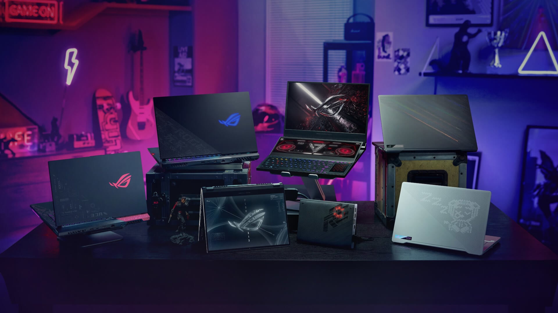 Multiple high-end ASUS ROG gaming laptops on a desk.