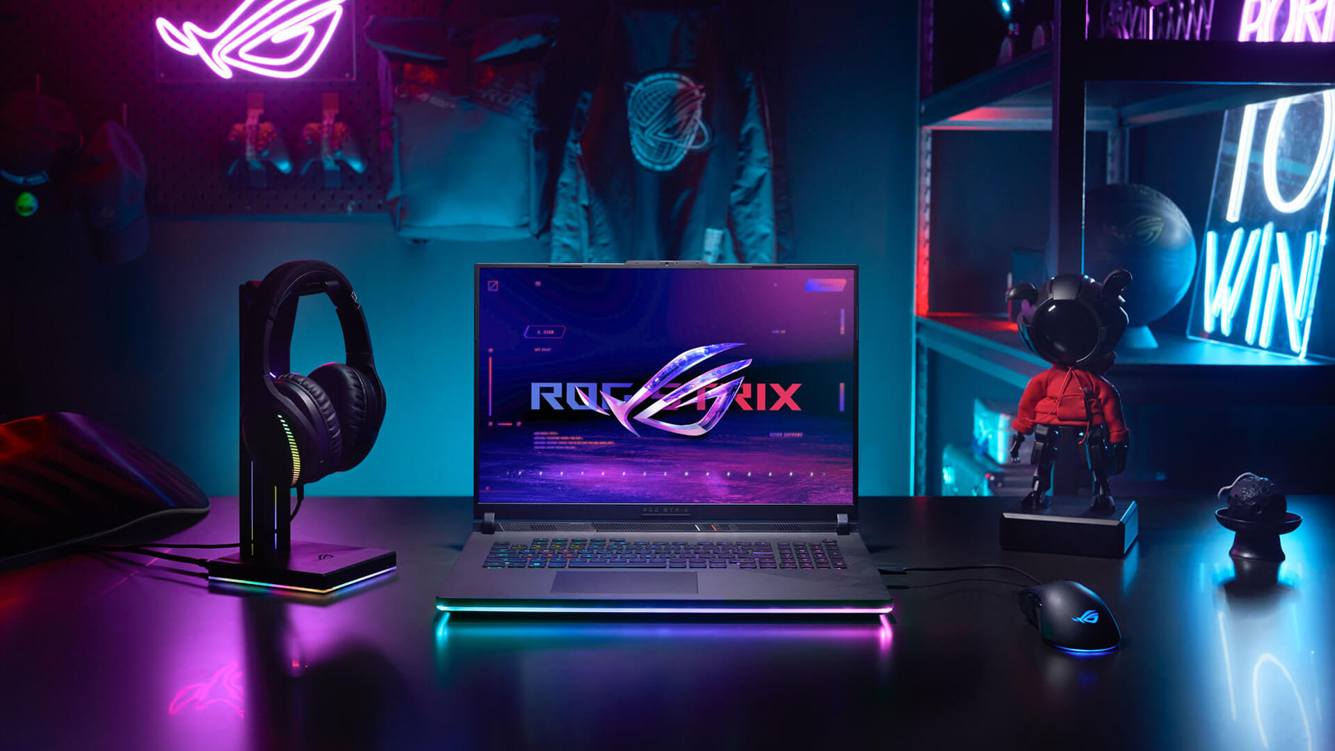 ASUS ROG Strix gaming laptop with neon lights on a desk.