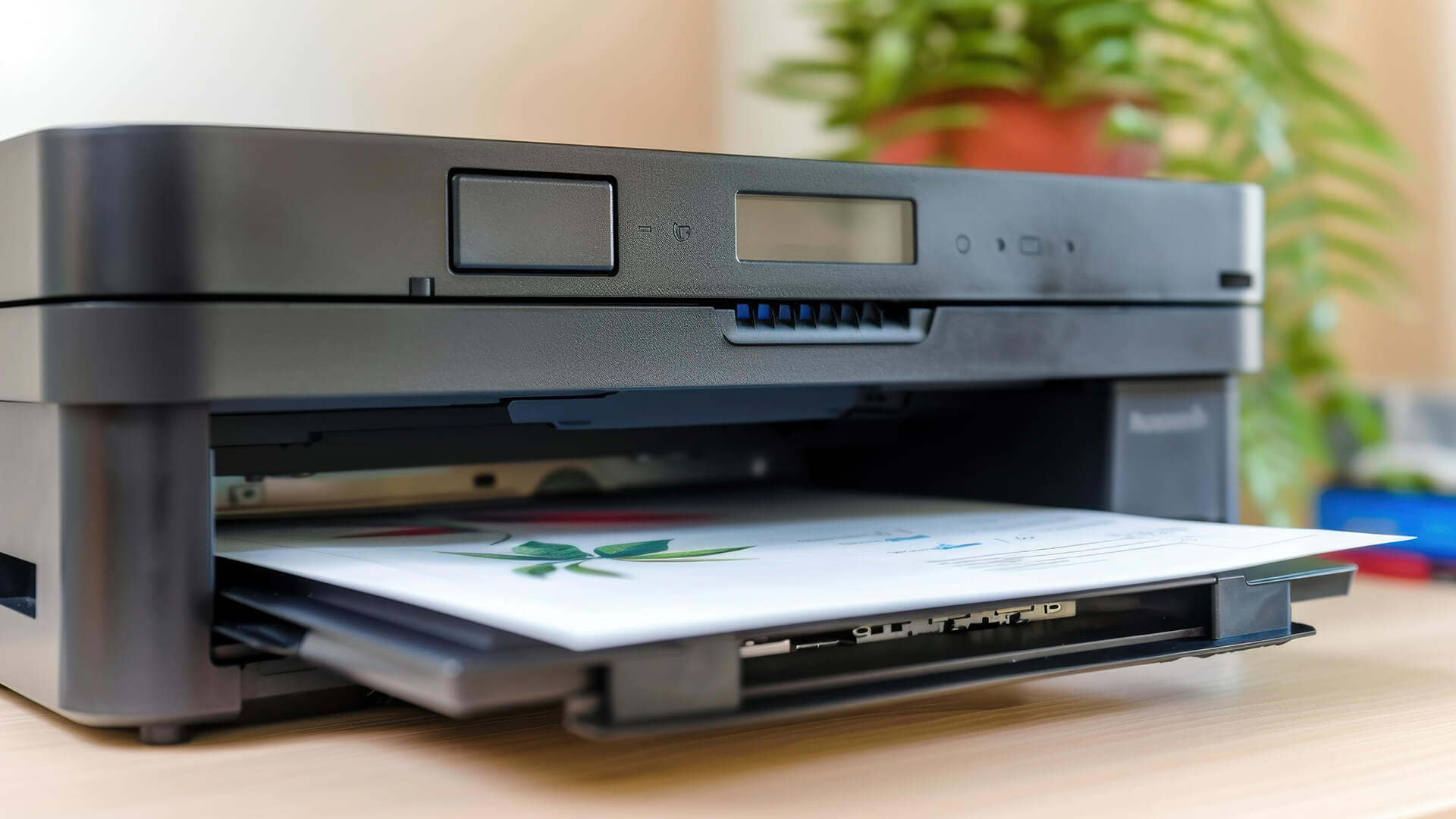 Close-up of a black laser printer outputting a color page.