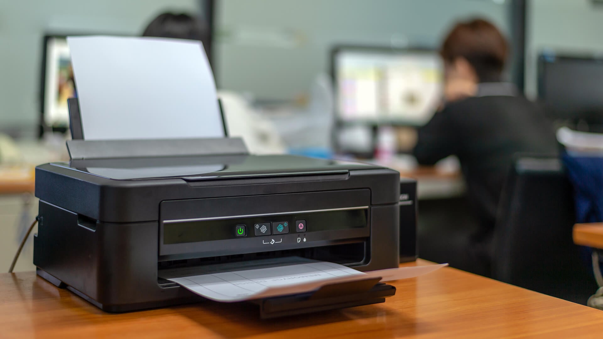 Compact inkjet printer printing a document in an office.