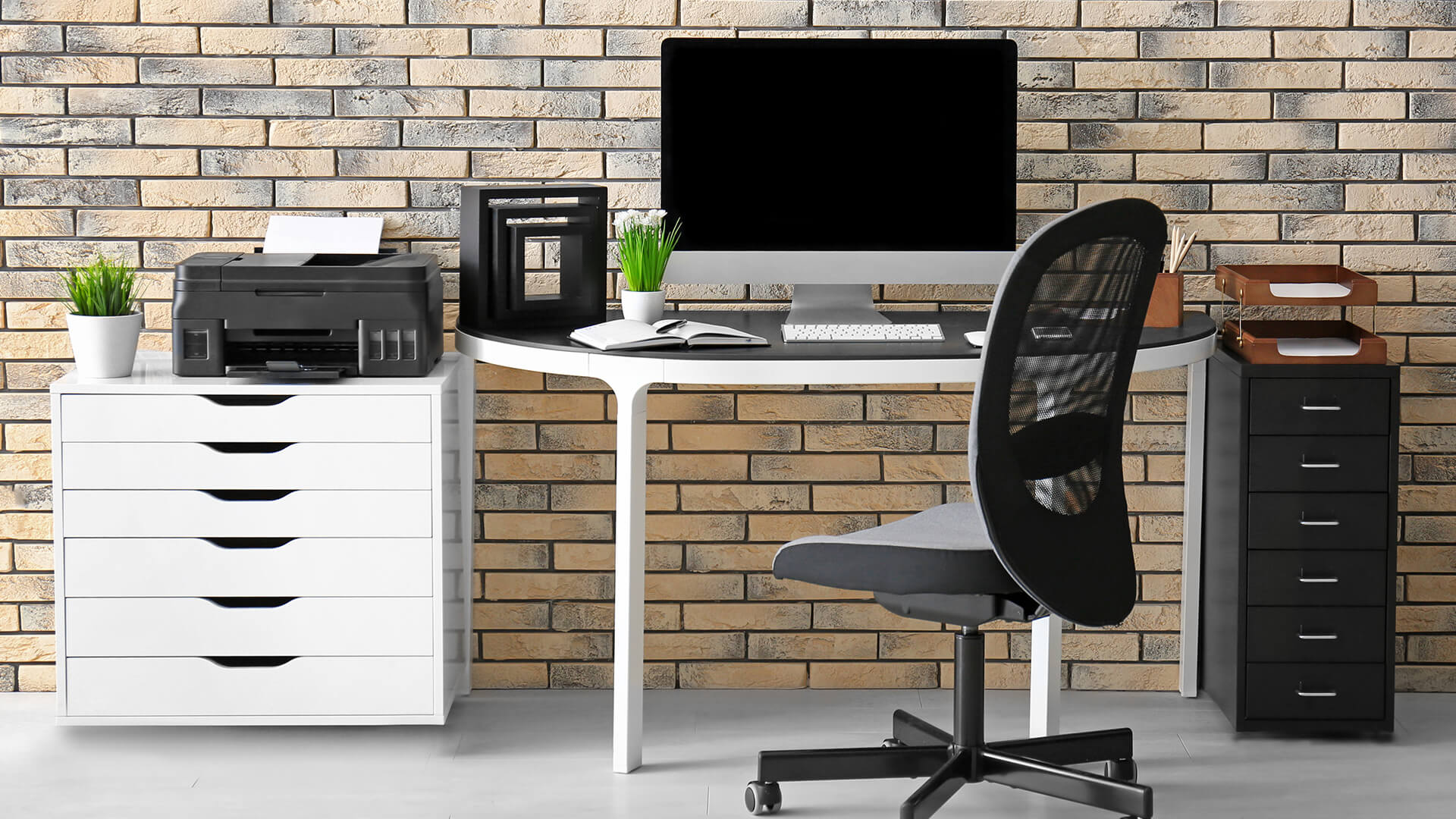 Compact wireless printer on a home office desk next to a PC.