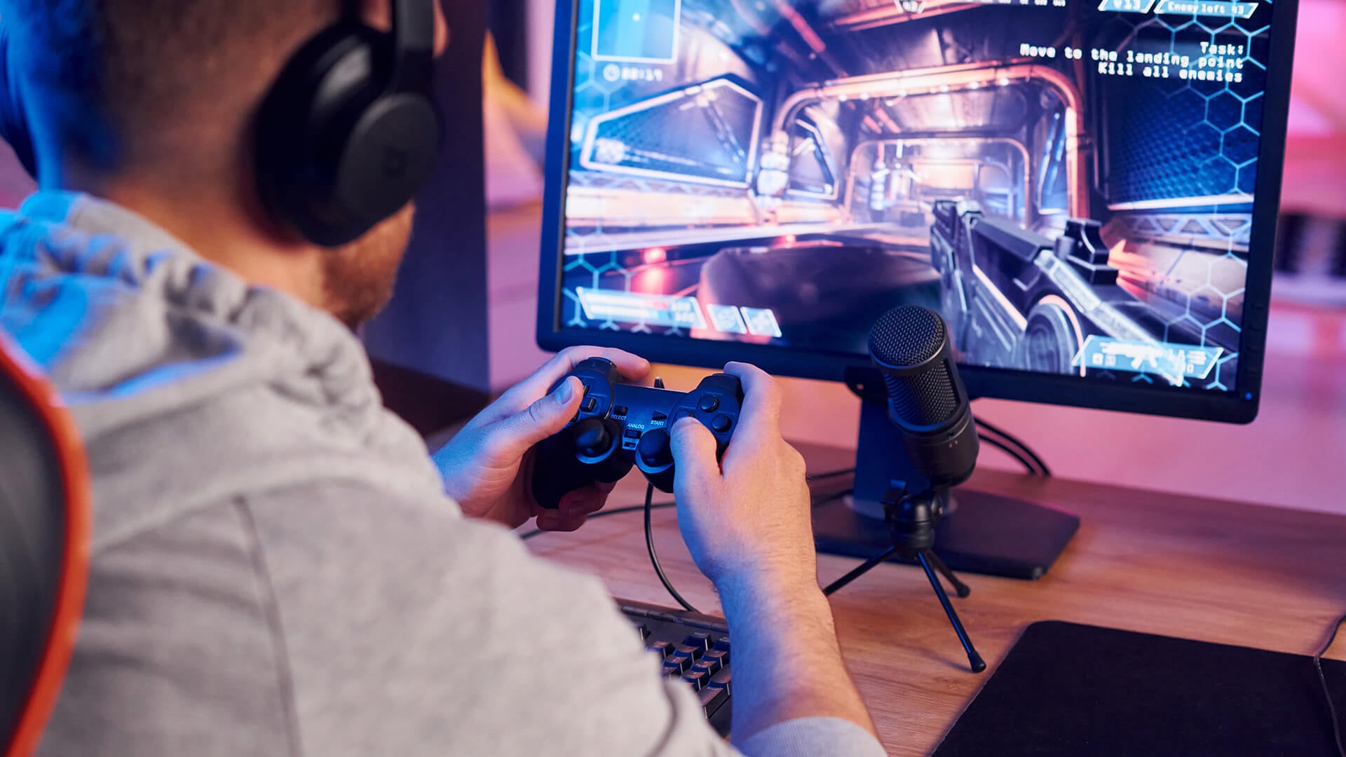 Gamer using a controller with a high refresh rate monitor.