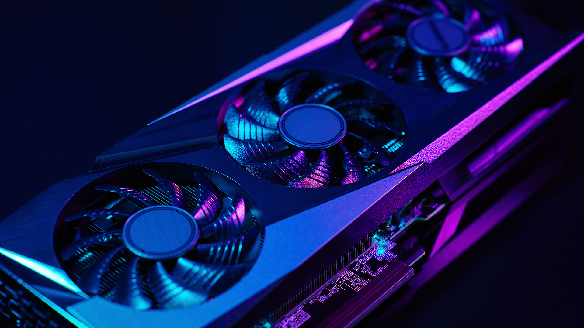 Triple-fan gaming GPU illuminated with blue and purple RGB lighting.