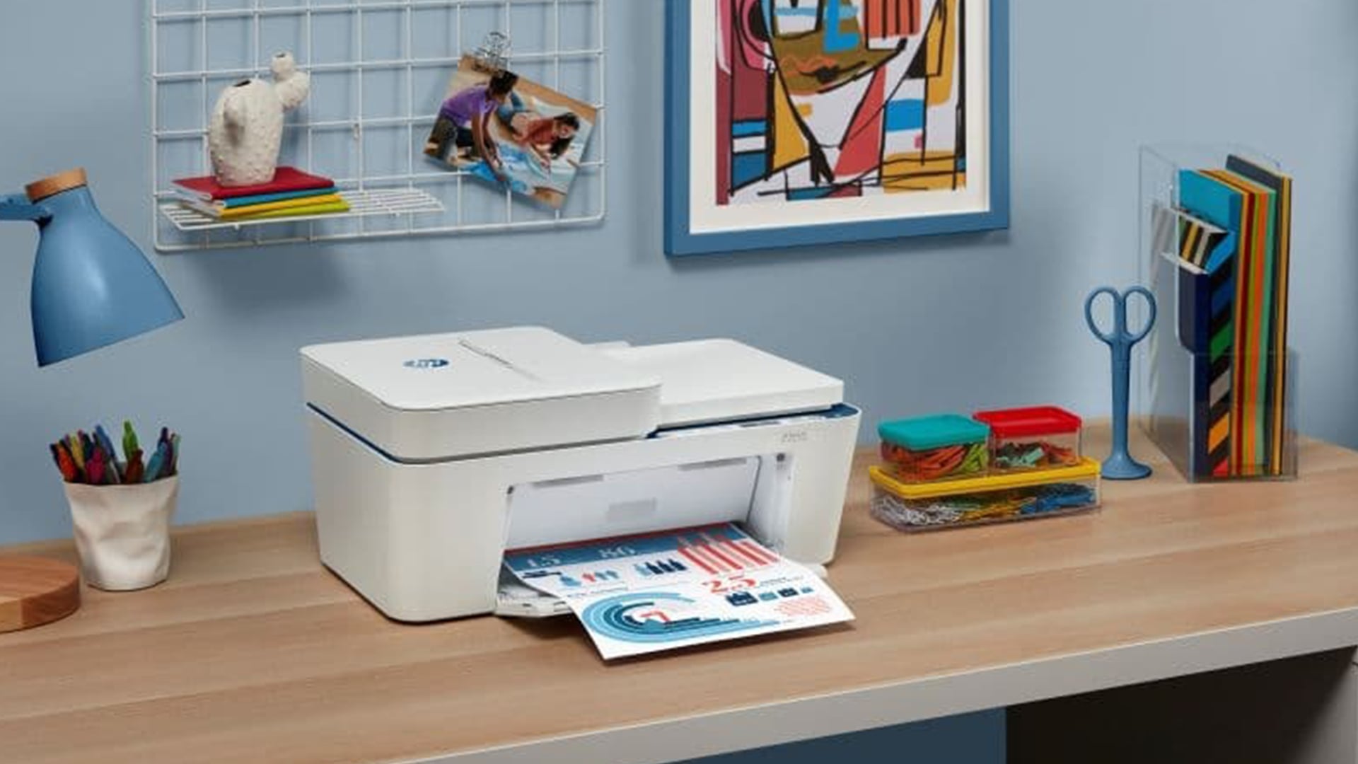 An HP all-in-one printer printing a document on a wooden desk.