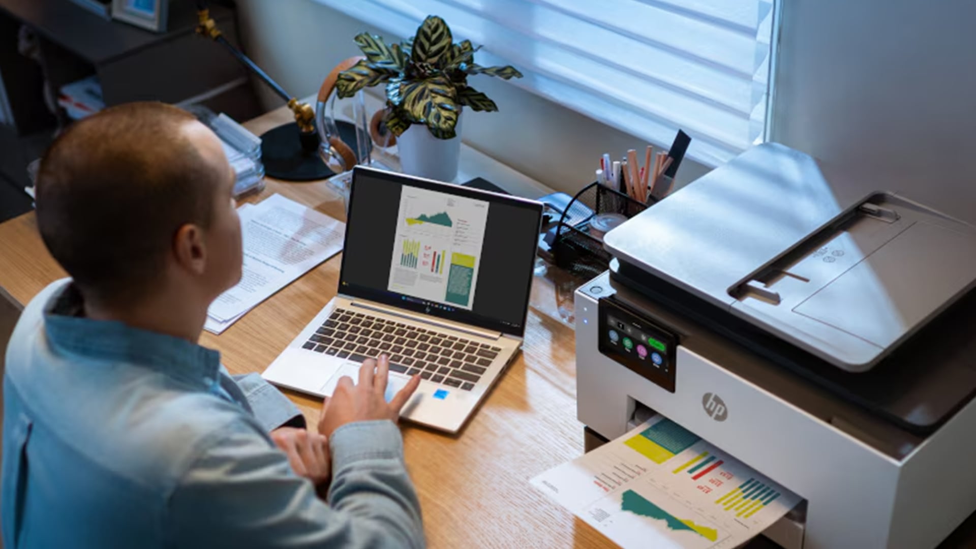 An HP printer outputting vibrant business color charts on a desk.