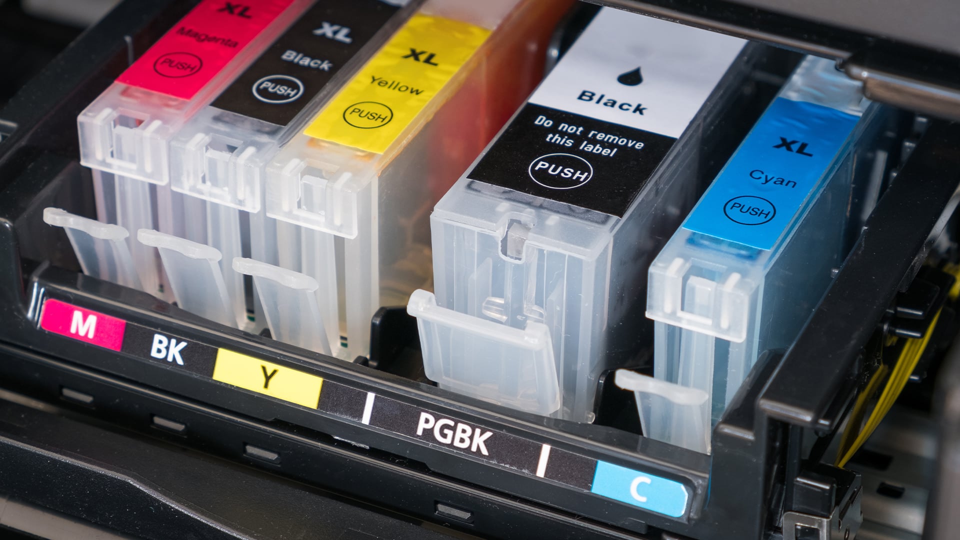 Close-up of empty ink cartridge slots in a printer.