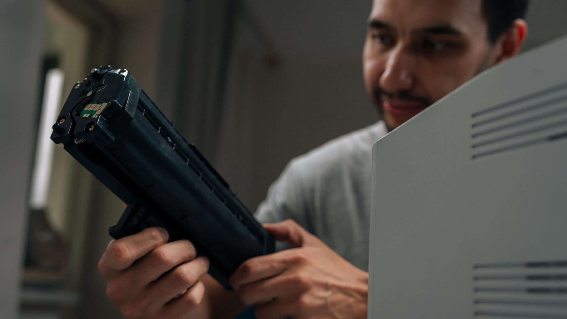 Man inspecting a Brother laser printer toner cartridge before setup.