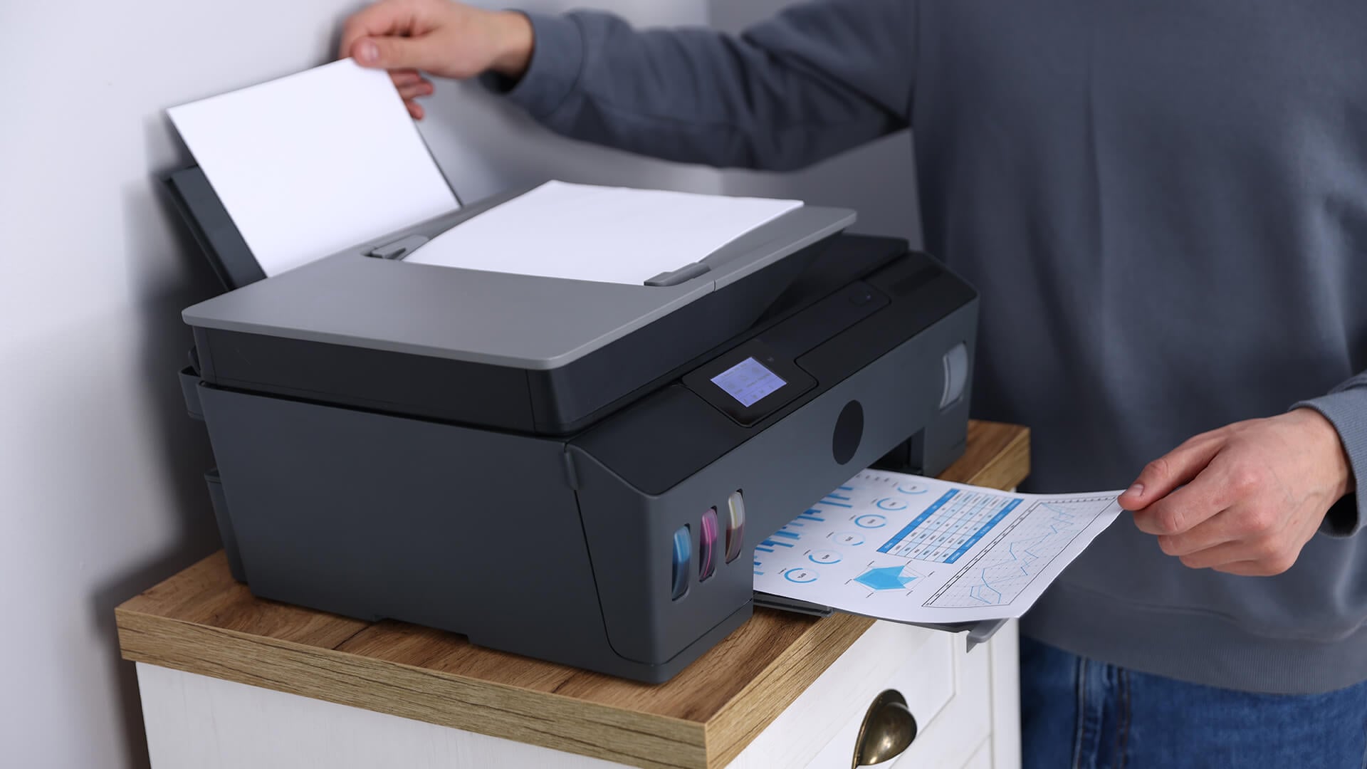 Man printing a business chart using an ink tank printer.