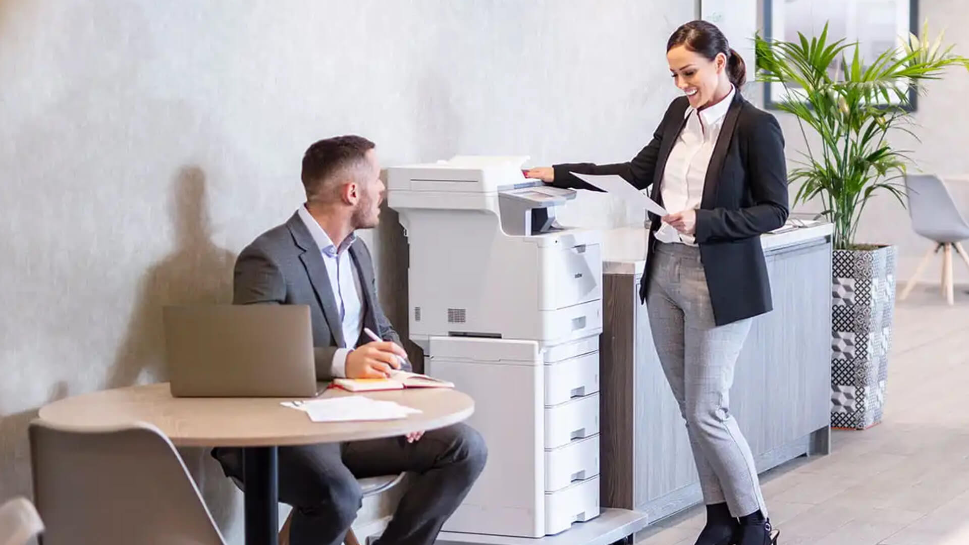 Business team in an office checking a Brother printer output.