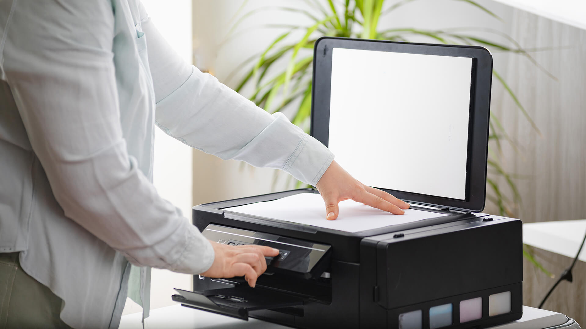 A person preparing to scan a document using a home all-in-one printer.