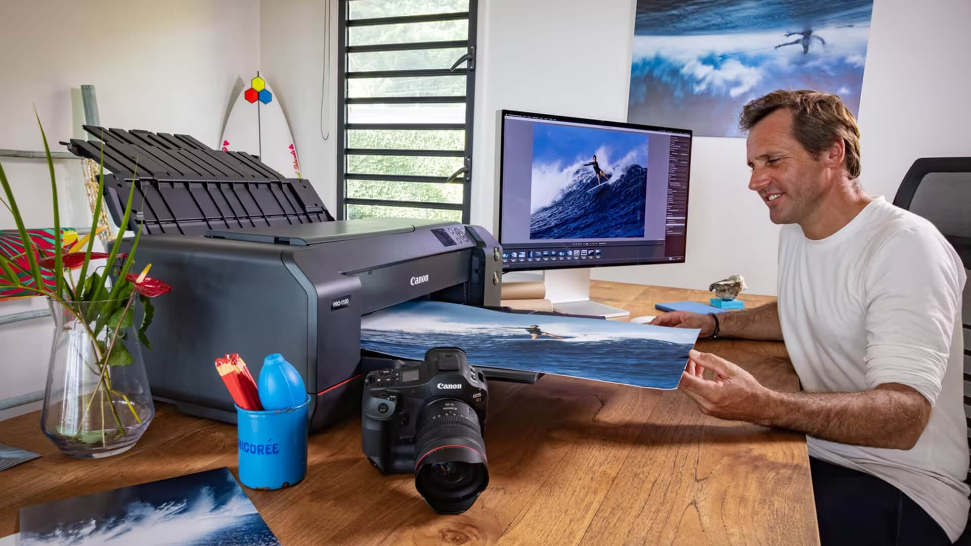 Photographer looking at a large printed photo of a surfer.