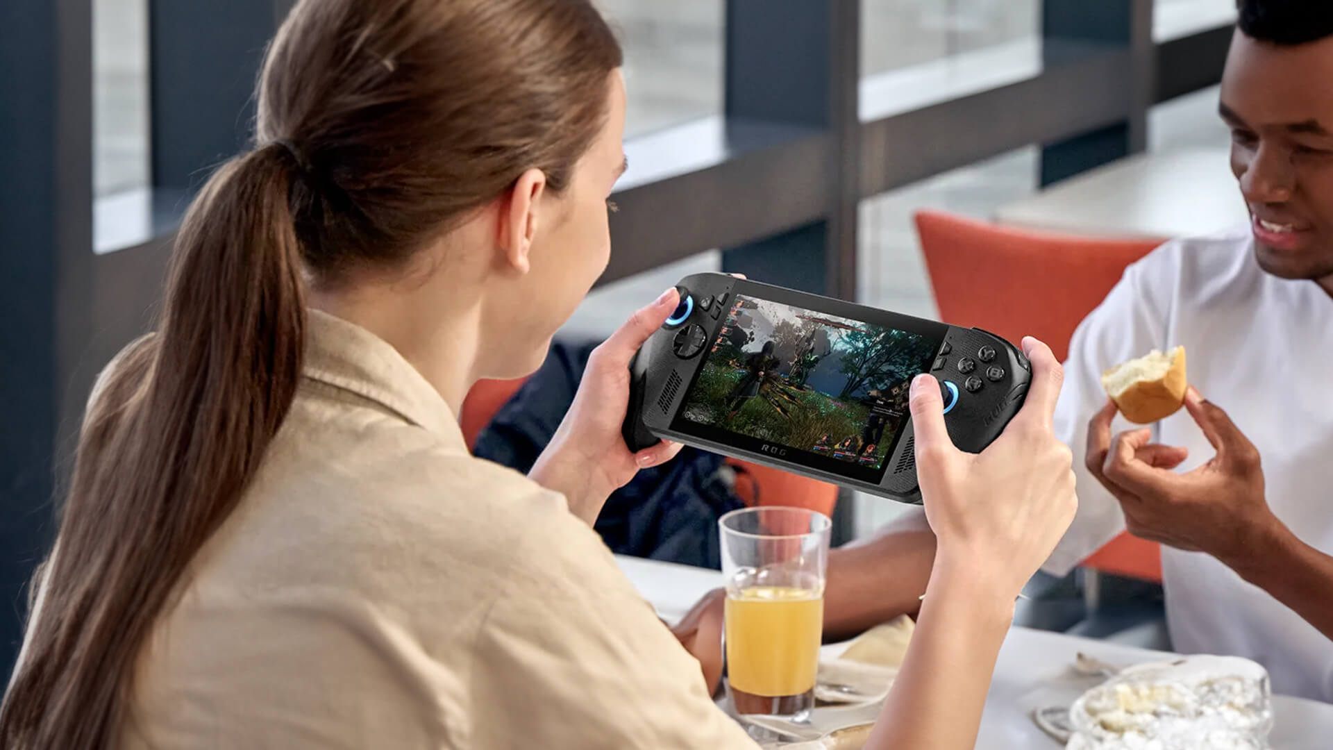A woman playing an action game on a black ROG Xbox Ally X.
