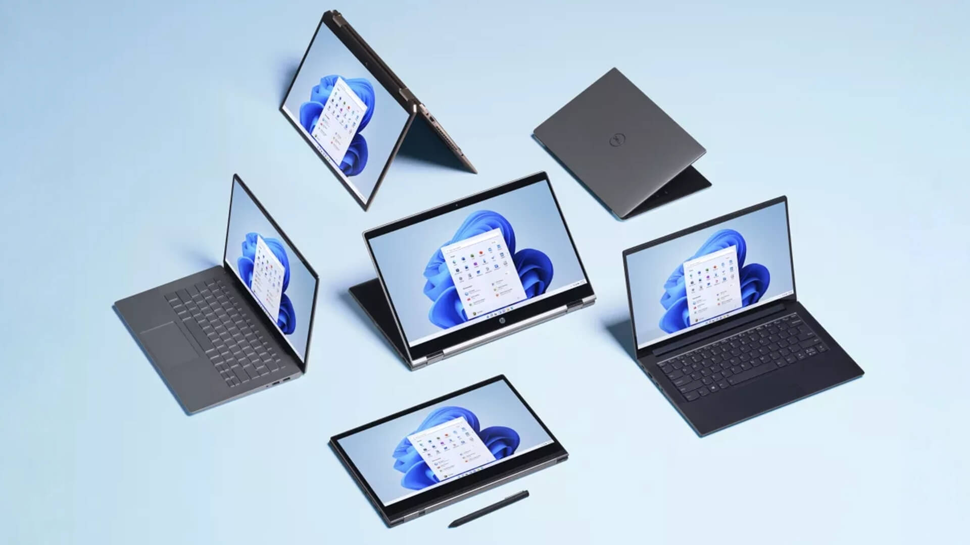 Several laptops and a tablet on a light blue background.