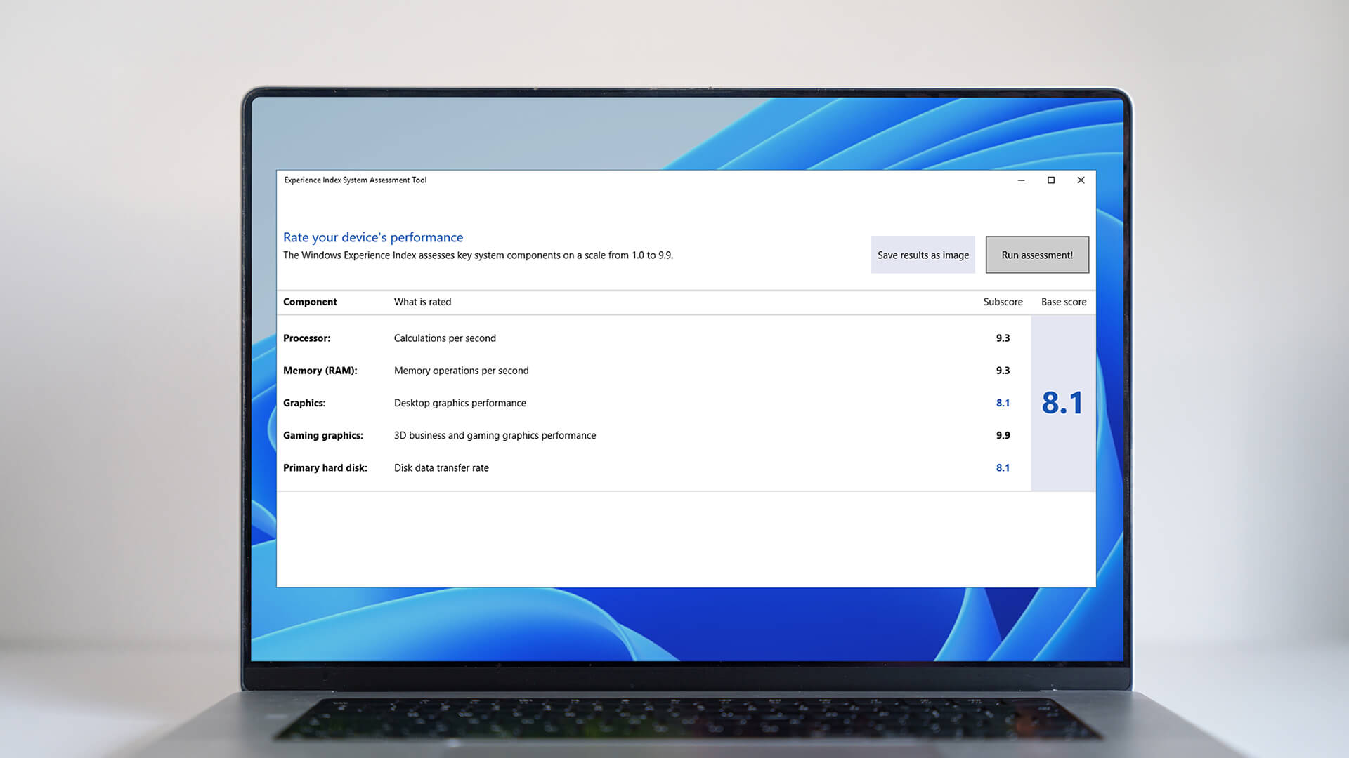 Black laptop on a desk showing a search for Windows PowerShell in the Start menu.
