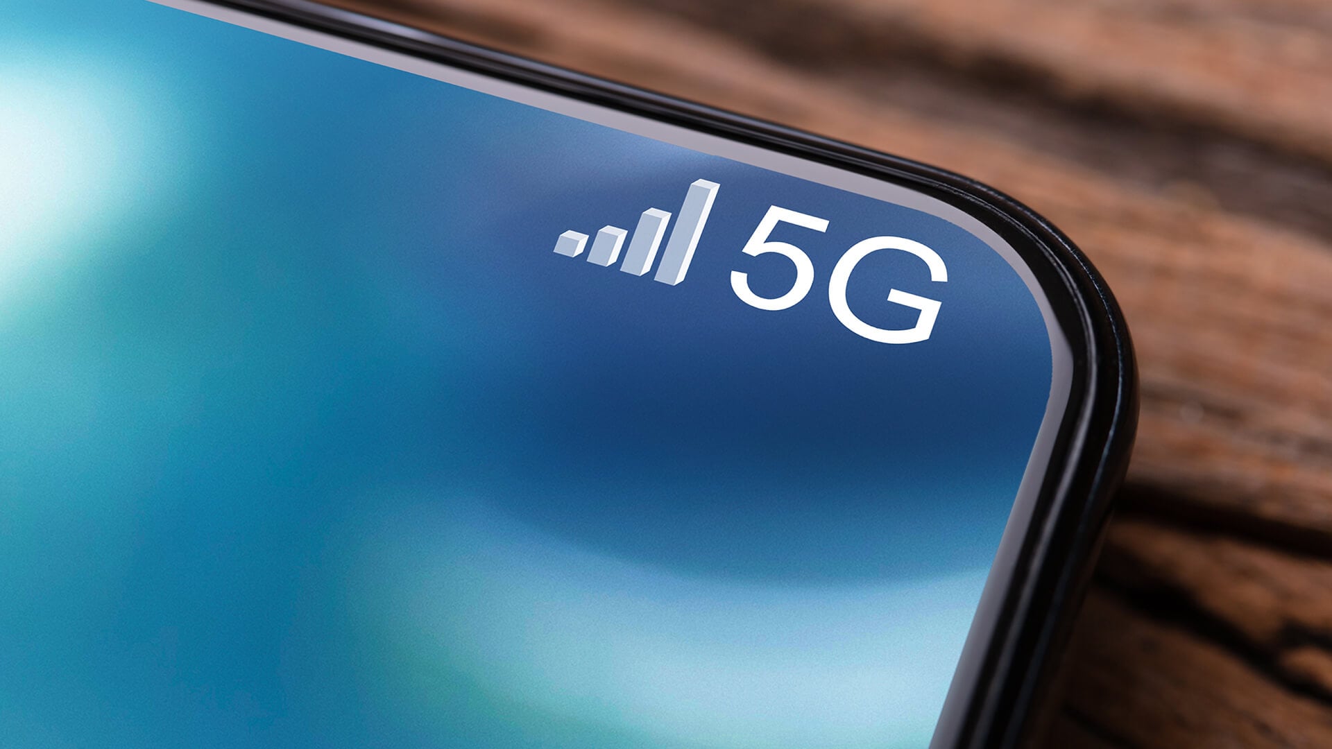 Close-up of a smartphone screen showing strong 5G signal bars.