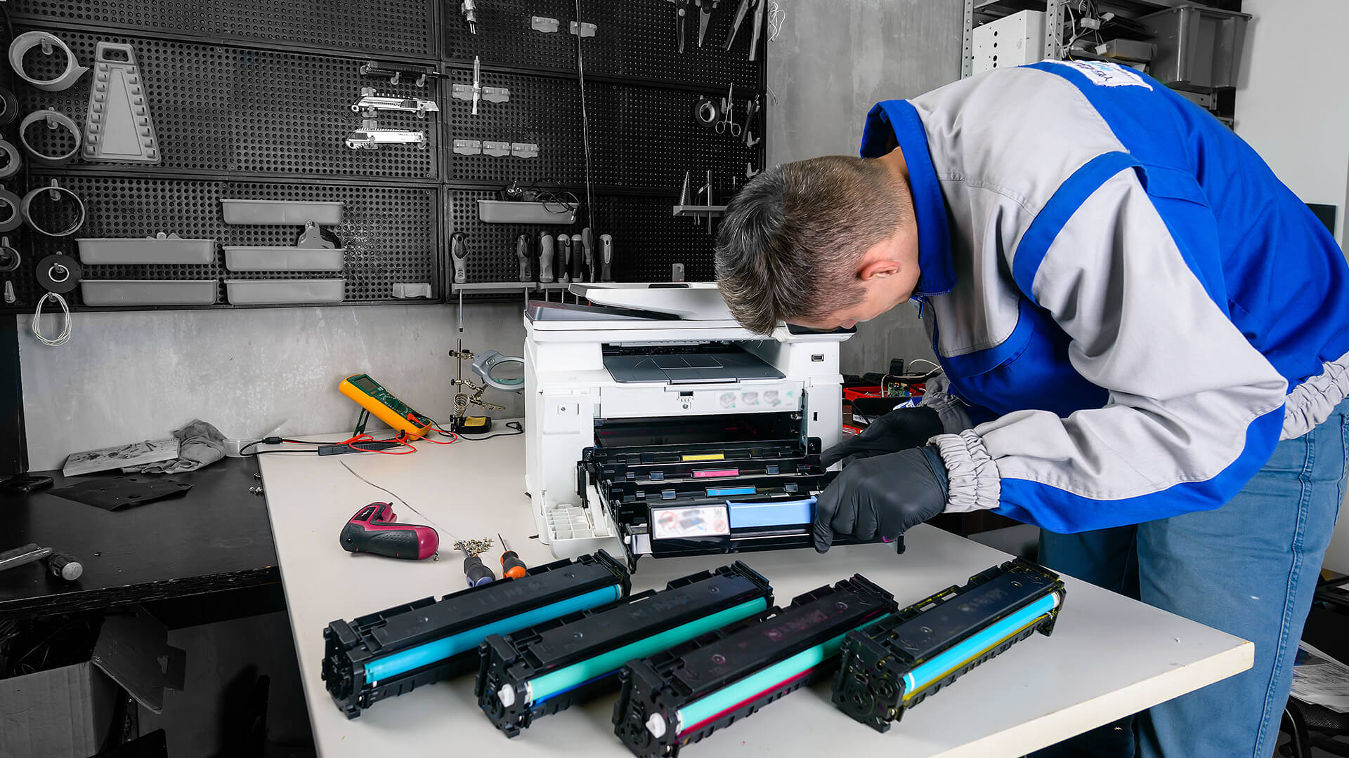 Technician repairing a laser printer and changing toner cartridges.