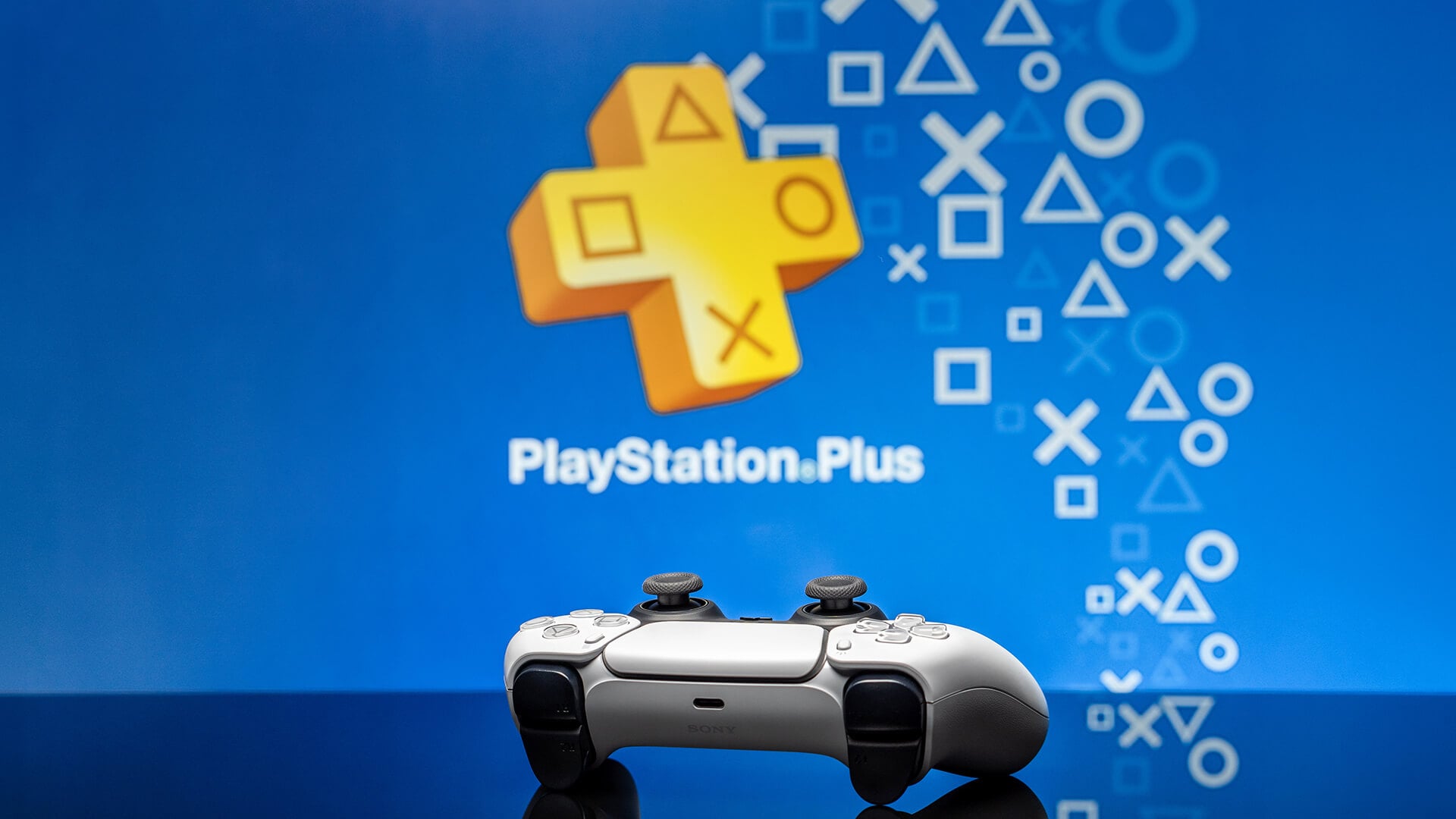 White PS5 controller against a blue PlayStation Plus background.