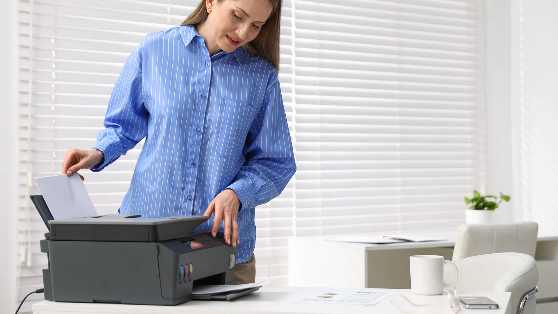 Woman printing business documents with an office inkjet printer.